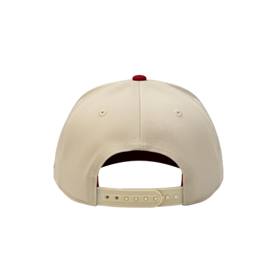 Back of a beige baseball cap with a red button on a white background
